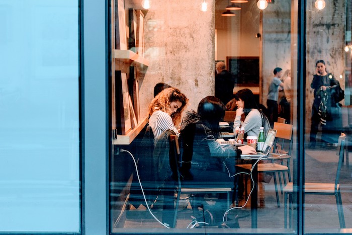 Group of people sitting around a table behind a glass window, image used for Ari Monkarsh post on how to hire the best employees